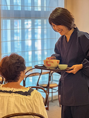 作務衣を着た店員と話す女性｜マルフク作務衣